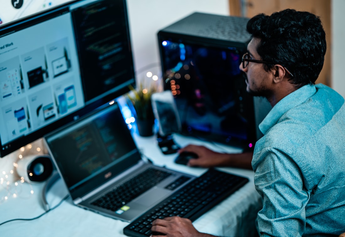 Zwei Entwickler an Bildschirmen mit Quellcode
